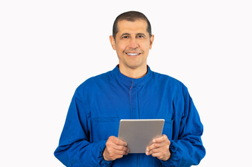 Confident smiling professional handyman in blue overalls using digital tablet against a white background.