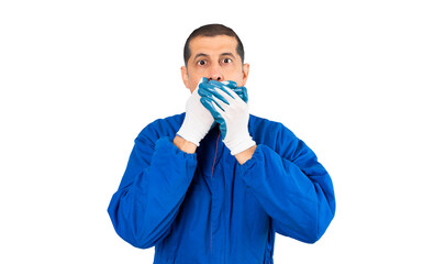 Shocked mechanic man covering his mouth with hands isolated on white background