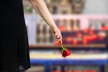 Flower, funeral and hand holding rose in mourning at death ceremony with grief for loss burial. Floral, church or cemetary with person holding plant for sad bereavement or cemetary event in a chapel