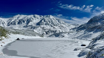 Fototapeta premium Frozen Lake and Snow-Covered Mountain Range