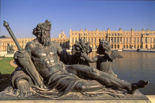 Versailles, France - 04 November 2025: View of the Neptune Fountain's bronze sculpture, with its muscular god reclining regally against the backdrop of the Palace of Versailles.