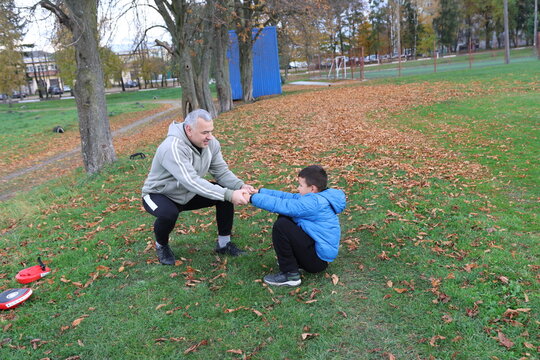 A man and a boy are training and practicing punches on training gloves