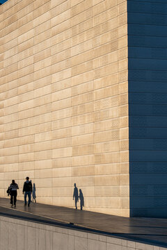 People in a modern urban city crossing a street surrounded by architecture reflecting daily lifestyle movement and connection in contemporary community spaces
