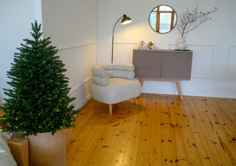 Cozy Christmas living room interior with a natural Christmas tree with light bulbs.