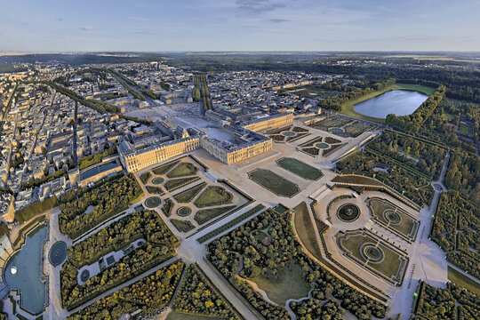 Versailles, France - 04 November 2025: Aerial view of the Palace of Versailles and its elaborate gardens, a symphony of structured greenery and reflective water features.