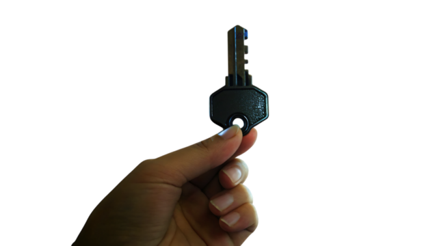 Hand holding a black key isolated on a white background, depicting danger and crime or security
