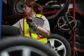Female hispanic technician inspect used car damaged part at scrap yard warehouse recycle area....