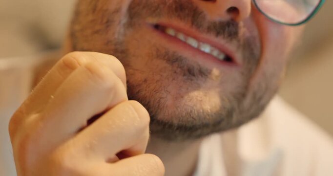 Close-up of a man pulling out a beard hair in discomfort. Concept for stress habits, skin irritation, grooming, or beard care issues.