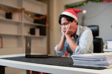 Young businessman feeling burnout working late during Christmas
