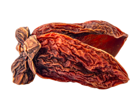 Two wrinkled, dried fruits, brown-orange, against a black background