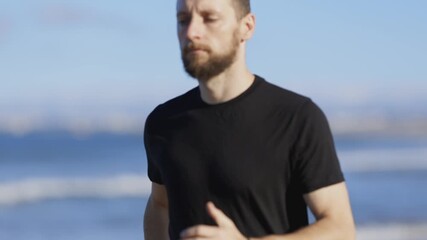 Athletic man running barefoot on the beach