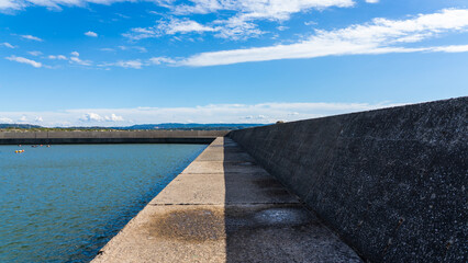 Long Concrete Breakwater under Clear Blue Sky