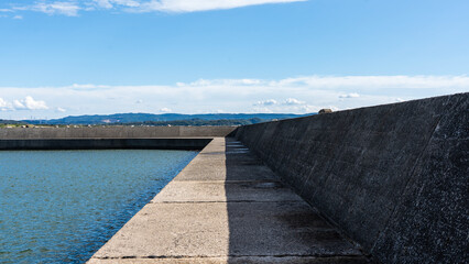 Long Concrete Breakwater under Clear Blue Sky
