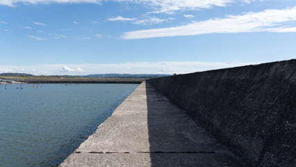 Long Concrete Breakwater under Clear Blue Sky