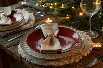 Christmas dinner table setting. Elegant crockery on rustic wooden table.
