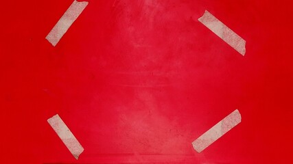 Four strips of masking tape on a vibrant red background adhesive