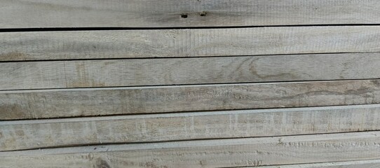 Stacked weathered grey wooden planks with visible grain lumber timber