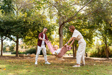 Ukrainian family playing with baby in park during autumn