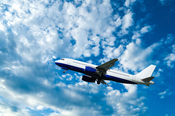 Flying airplane with blank livery, travel background with airplane flying in the blue sky, air travel concept with airplane in the flight