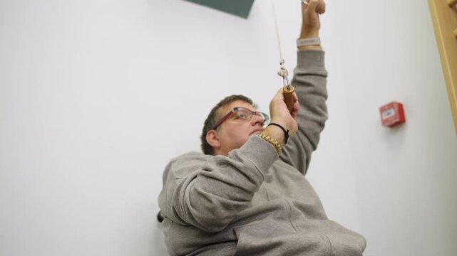 Man with disability in wheelchair doing physical therapy exercises