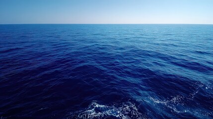 Fototapeta premium Deep Blue Ocean Waters Reflecting Sunlight under Clear Blue Sky in Horizontal Shot with Sparkling Water and Calm Seas in Daytime for Stock Image Use