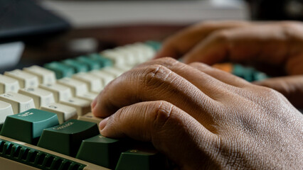 Macro view of hands typing on a retro-style mechanical keyboard, focus on skin texture and key details, with blurred depth emphasizing a working moment.