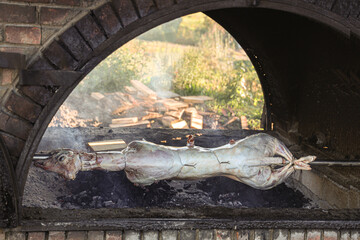 Lamb barbecue of a whole sheep with head, also called mechoui, traditional meal from europa Festive meal concept. carcass of the goat is fried on a spit. cooking whole animal roasting an over low heat