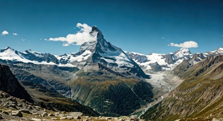 Majestic mountain peak piercing a partly cloudy sky, valley below with glaciers and green slopes