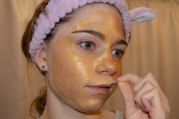 A golden mask on the face of a teenage girl