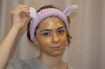 A golden mask on the face of a teenage girl