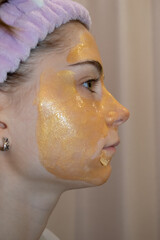 A golden mask on the face of a teenage girl