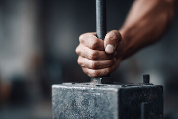 Closeup of a hand firmly gripping a metal rod, conveying strength, determination, and industrial work. Ideal for themes of manufacturing, engineering, or labor.