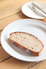 Artisan sourdough bread loaf sliced on parchment paper Wooden table background