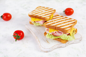 Delicious sandwich with ham, cheese, tomato and lettuce on toasted bread. Perfect lunch or snack idea