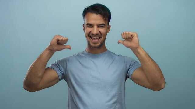 Hispanic man pointing at himself with thumbs over isolated blue background, expressing confidence and self-assurance in a casual setting.