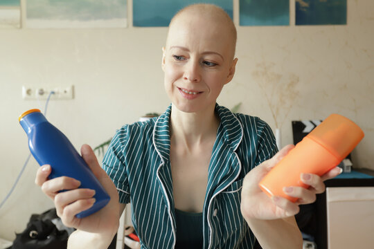 Smiling woman compares SPF skincare bottles, choosing safe sunscreen for oncology skin after chemotherapy