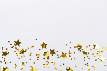 Golden star shape confetti on color background, top view