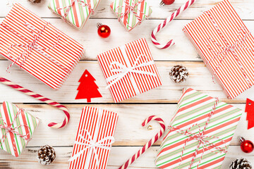 Fototapeta premium Many striped Christmas gift boxes on wooden background, top view