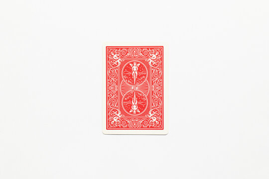Bradford, UK Nov 3 2025 - The back of a distinctive red bicycle playing card with the angel riding on a bike, shot isolated on a white paper background.