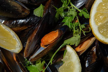 Close-up of traditional Spanish mussels dish with lemon and parsley in sunlight