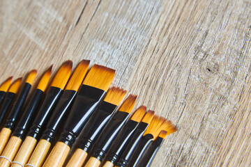 A set of new artist paintbrushes on a wooden table background.