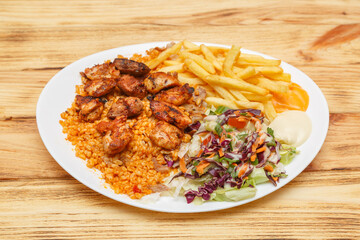 Assiette brochette de poulet servie avec blé, frites et salade – restauration rapide turque halal