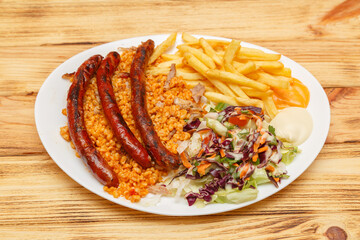 Assiette merguez servie avec blé, frites et salade – restauration rapide turque halal