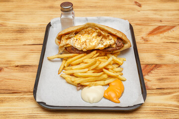 Sandwich royal steak et œuf sur un plateau avec frites et sauces – restauration rapide turque halal