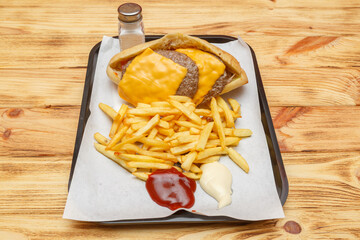 Sandwich steak cheddar sur un plateau avec frites et sauces &ndash; restauration rapide turque halal
