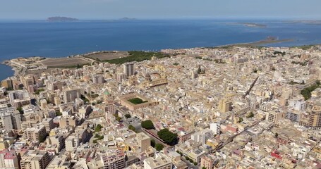 Aerial view of houses and buildings in the historic center of Marsala, in the province of Trapani, Sicily, Italy. In the background, on the horizon, are the Mediterranean Sea and the Aegadian Islands.