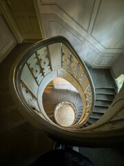 Looking down an ornate spiral staircase with white railing