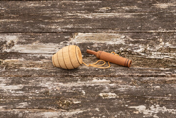 Brazilian wooden spinning top and thrower (batoque), connected by string, displayed on a weathered rustic wooden table. Outdoor setting. Symbolizes traditional Brazilian games, culture, and childhood.