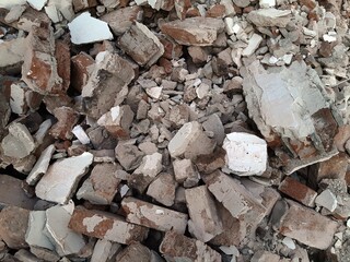 A pile of broken red bricks and fragments of concrete. Pile of debris of a torn down building