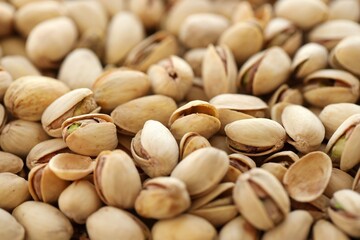 Tasty unpeeled pistachios as background, top view flat lay background